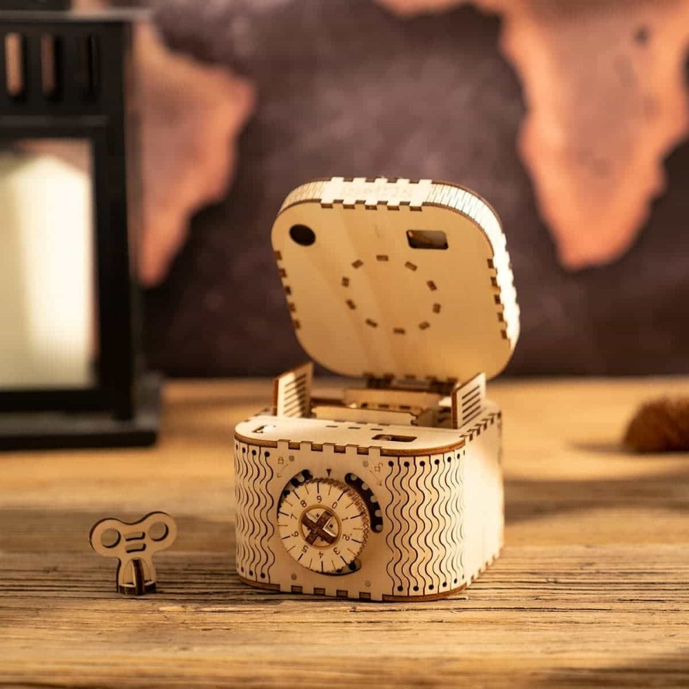 Wooden mechanical model of a box with a key on a wooden surface