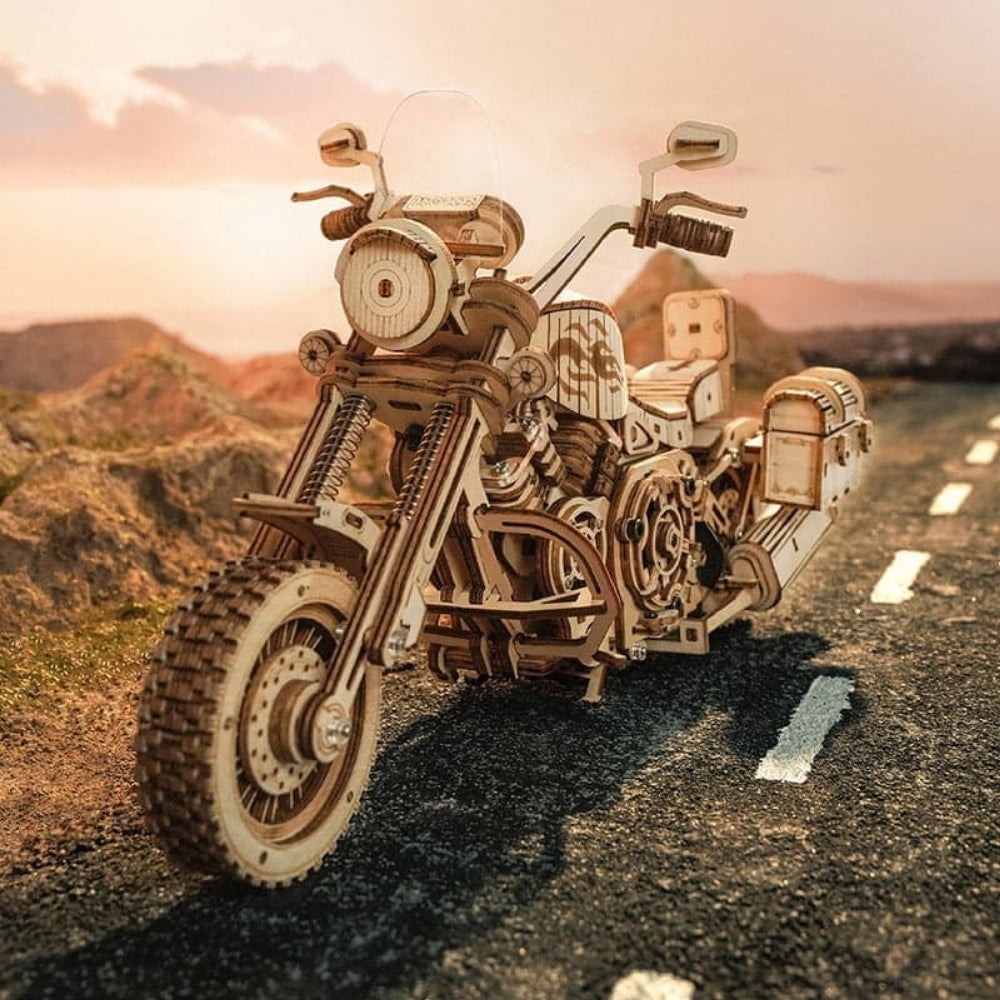 Wooden motorcycle model on a road with mountains in the background