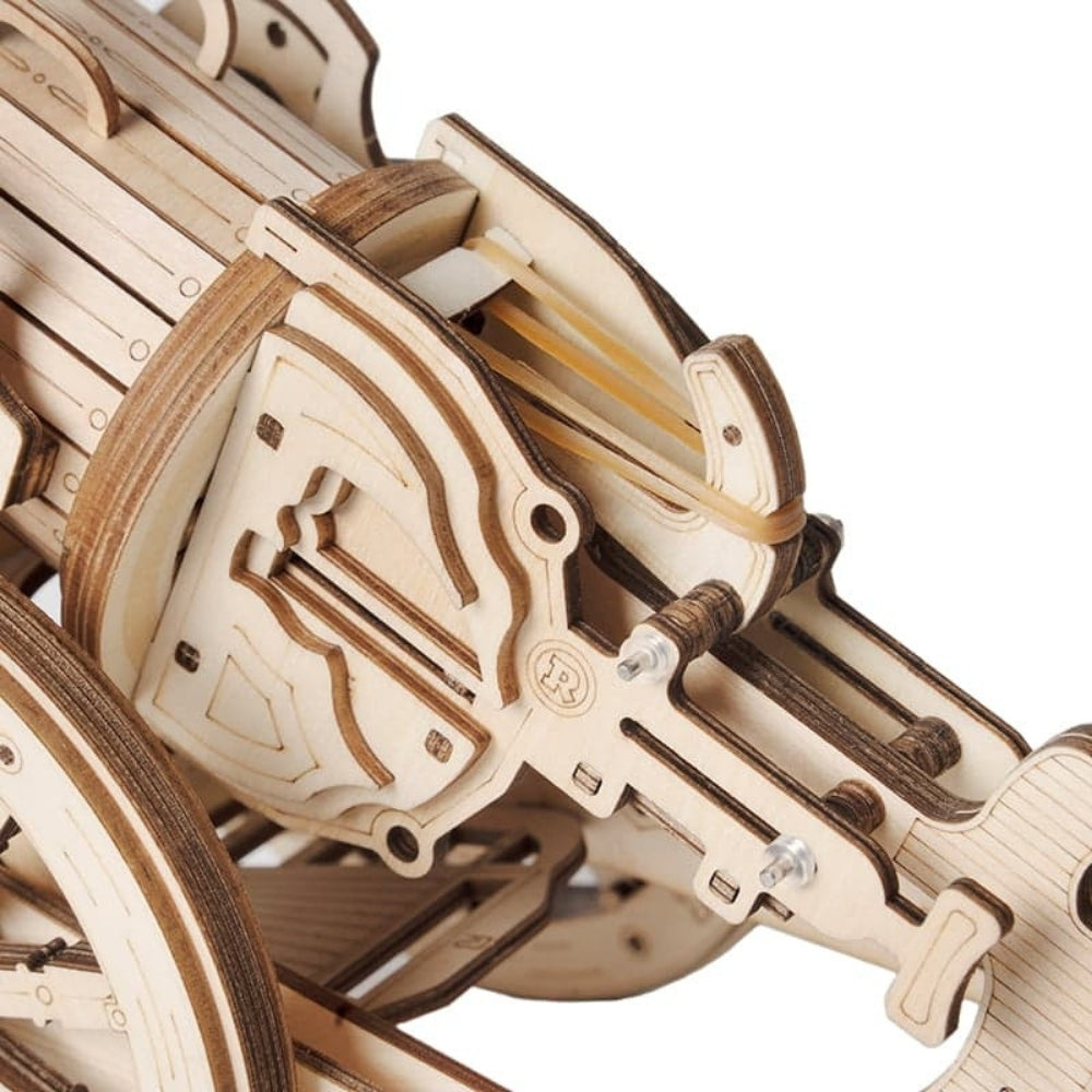 Close-up of a wooden mechanical model with intricate details on a white background