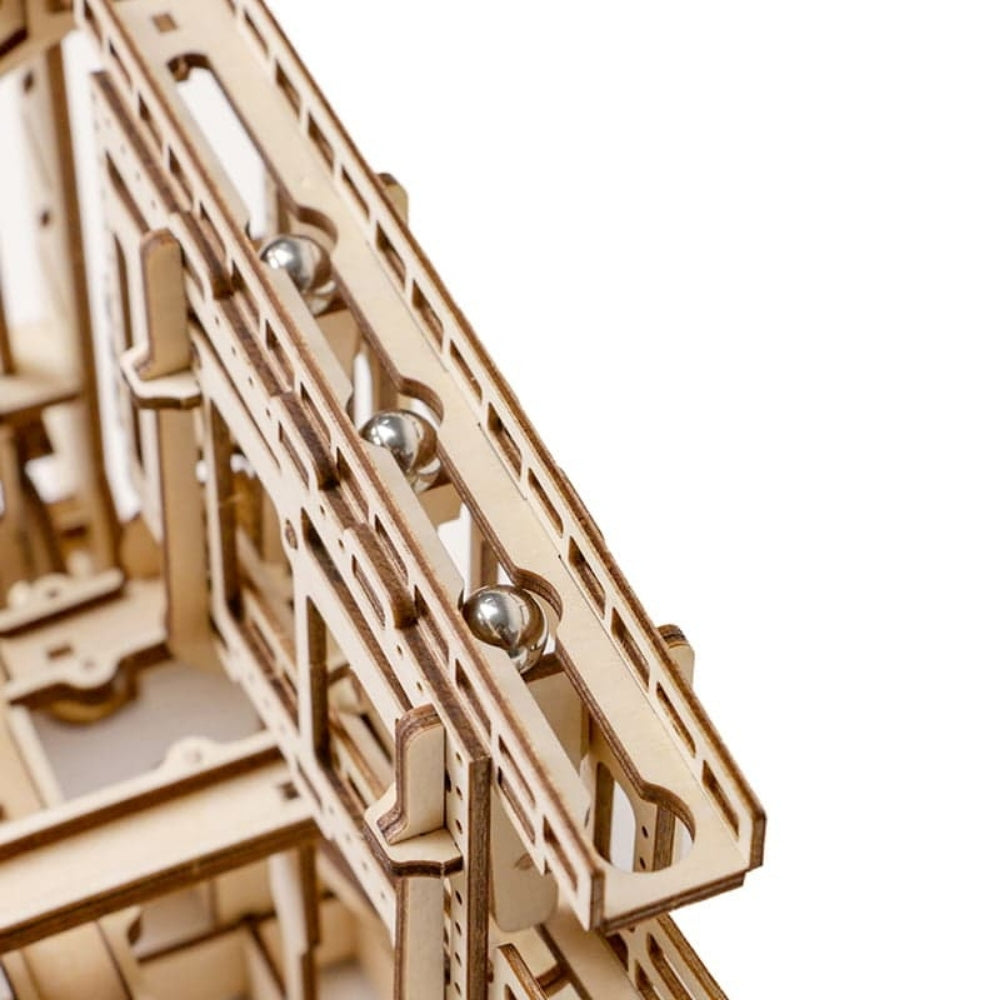 Wooden mechanical model with metal balls on a white background