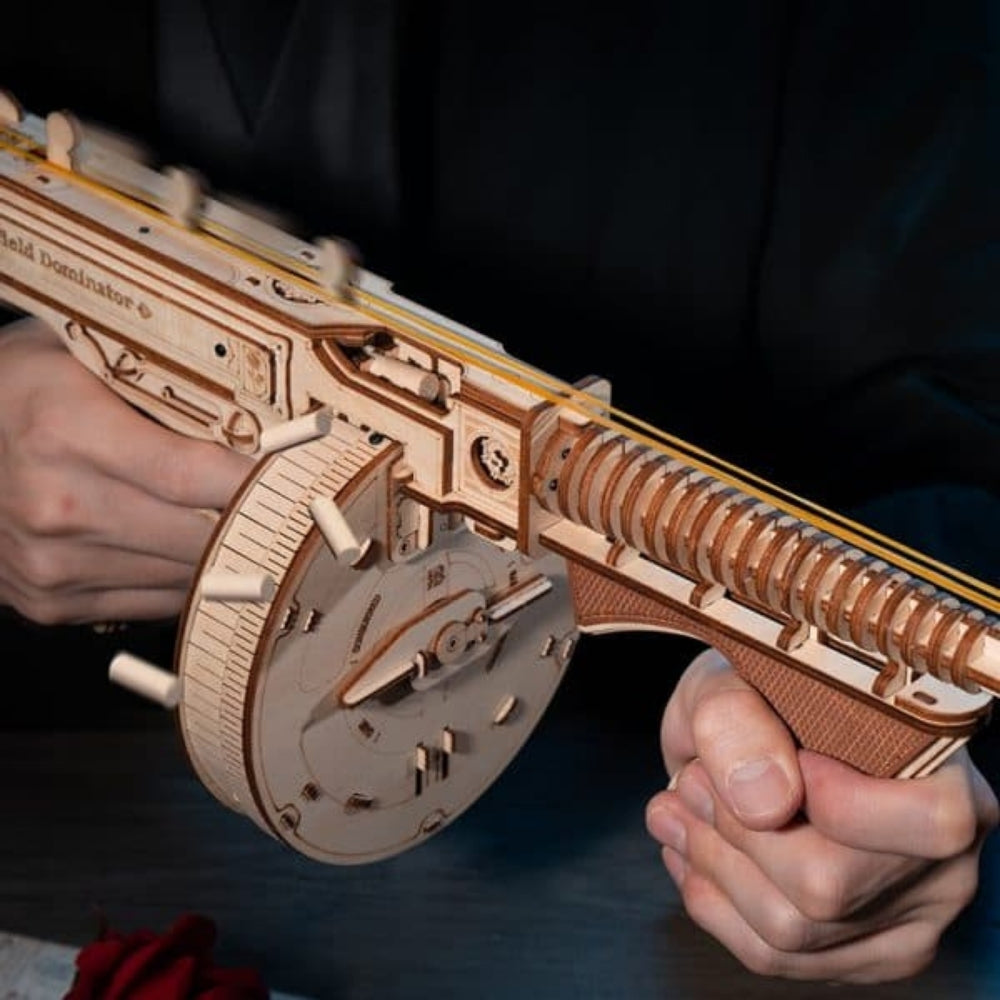 Wooden model gun held by a person against a dark background