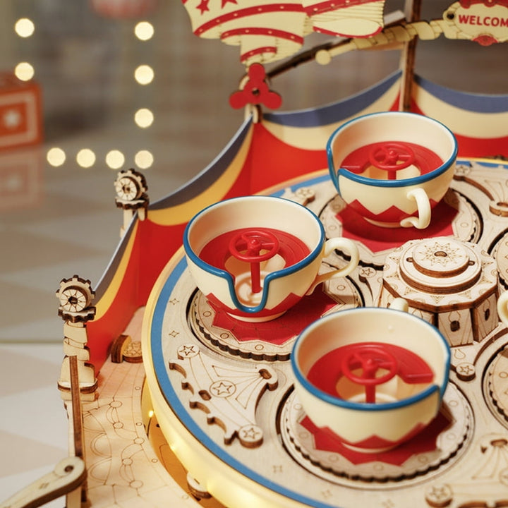 Wooden toy carousel with cups and saucers on a blurred background