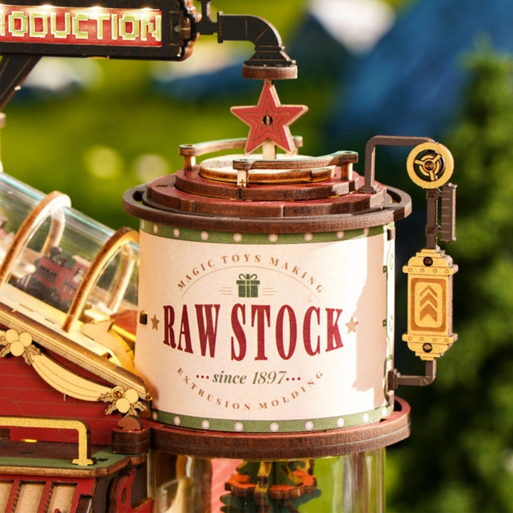 Toy factory model with 'Raw Stock' label and Christmas tree in the background