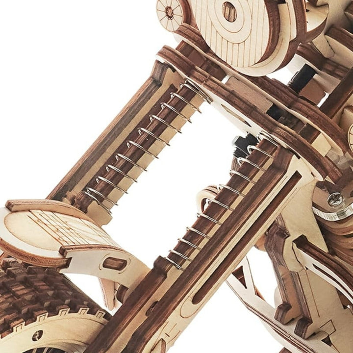 Close-up of a wooden mechanical model of a motorcycle on a white background