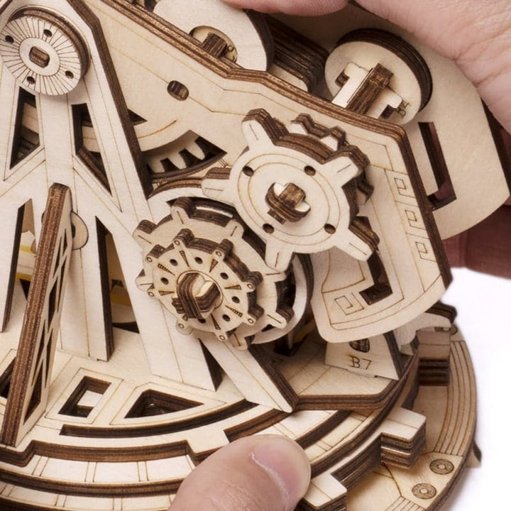 Close-up of a wooden mechanical model with gears and intricate details.