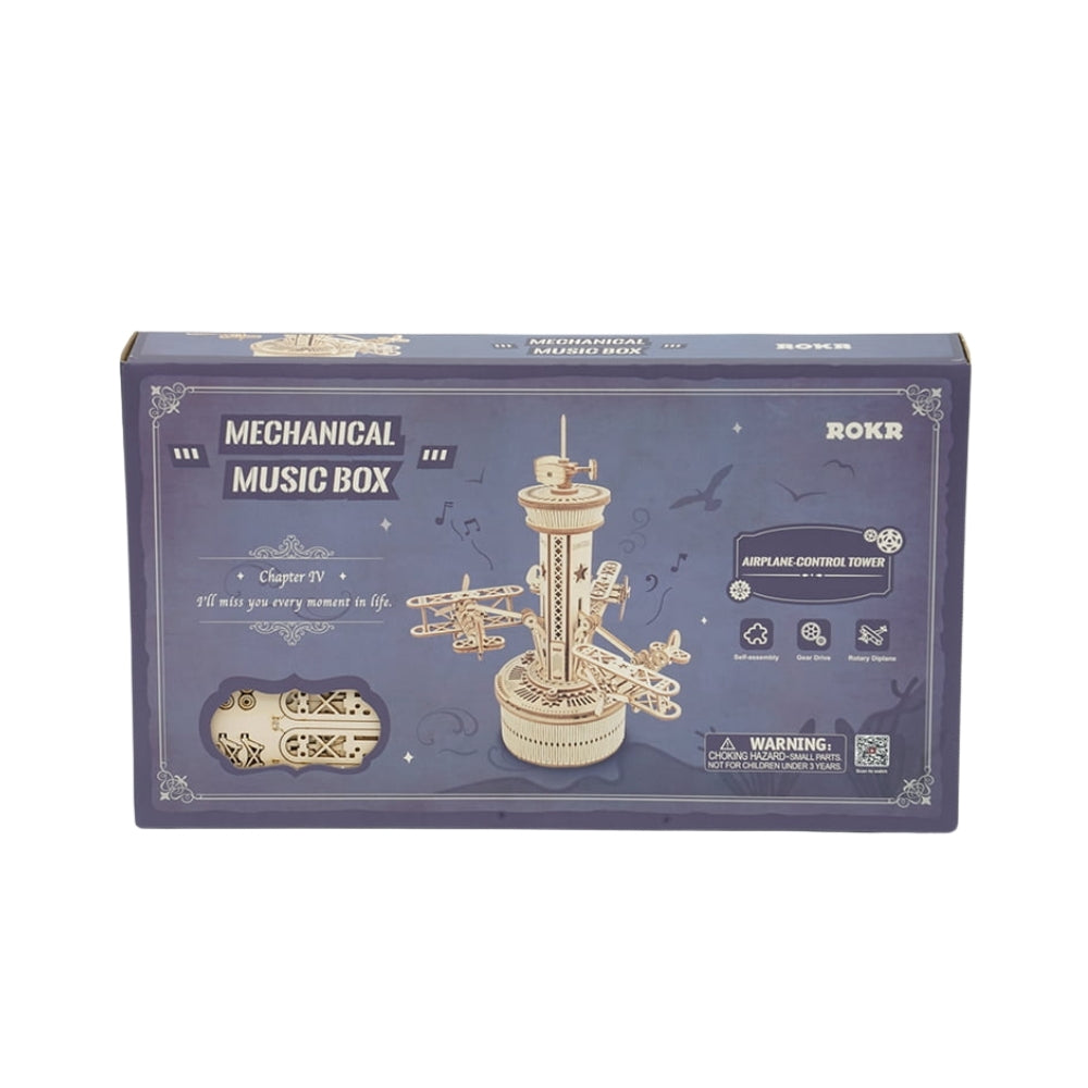 Boxed mechanical music box with tower design on a white background